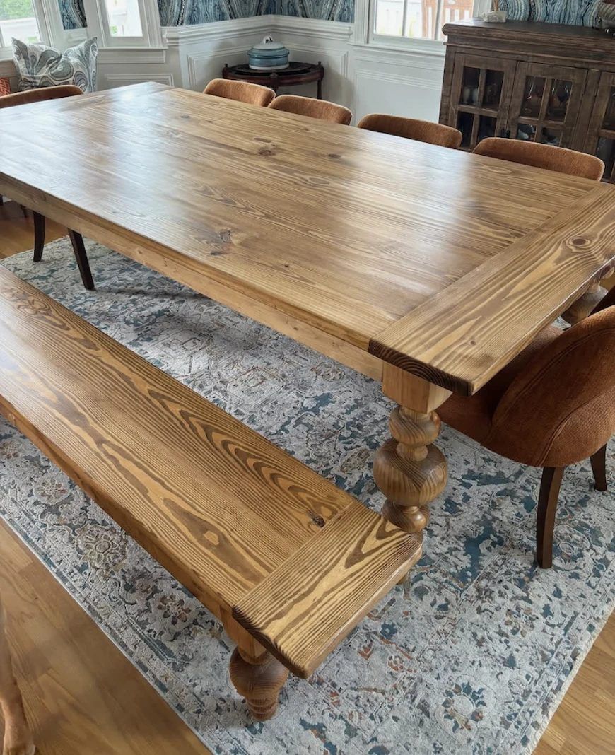 Close-up of breadboard ends and chunky turned legs on a stained pine table and bench
