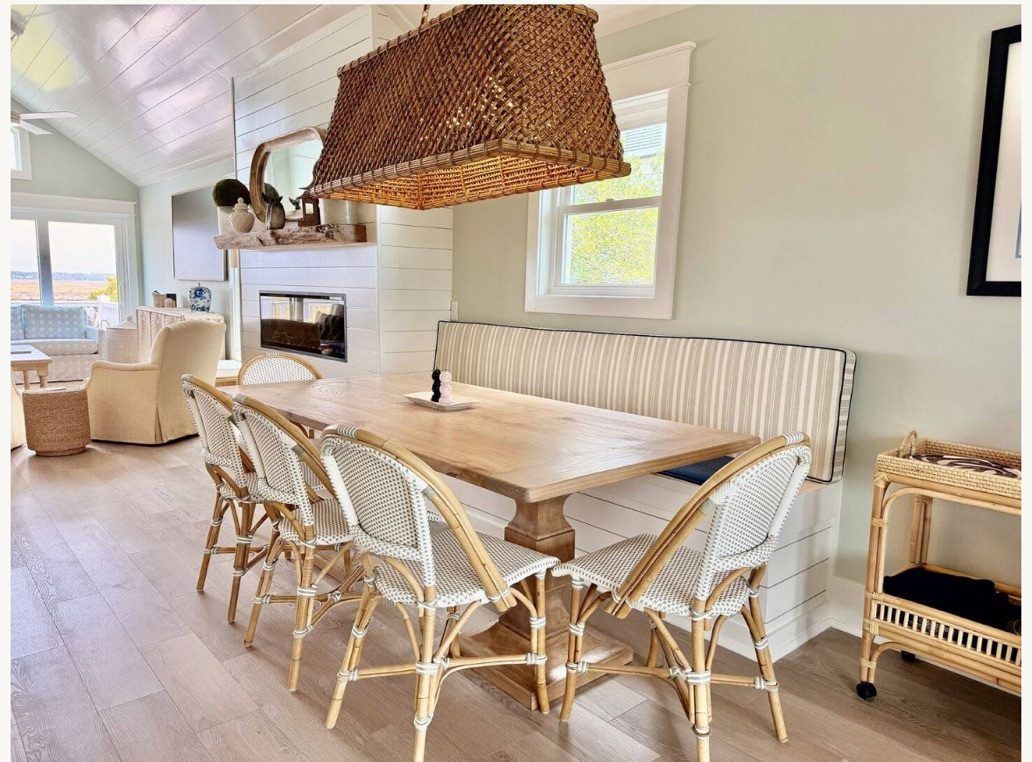 Square pedestal table with rattan bistro chairs in a coastal breakfast nook