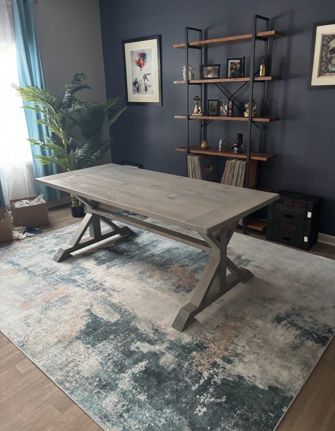 Pedestal trestle farmhouse table in weathered gray with braced legs on stepped feet